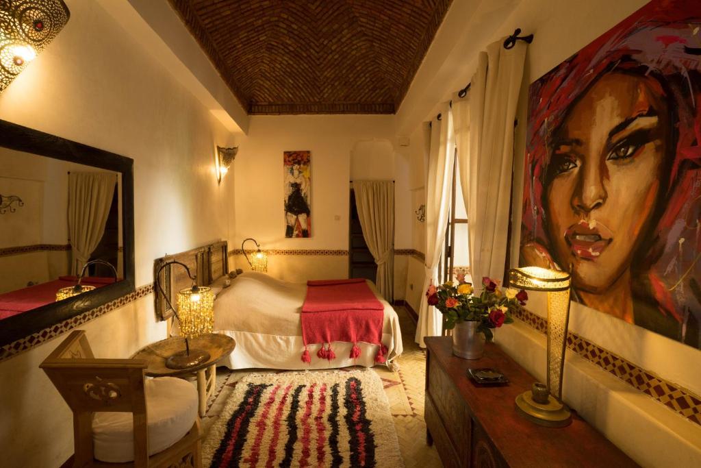 une chambre avec un lit et une grande peinture d'une femme dans l'établissement Dar Kleta, à Marrakech