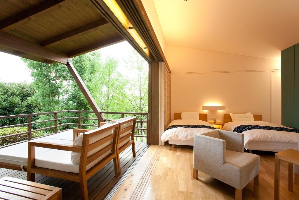 deux lits dans une chambre avec balcon dans l'établissement Satsuki Bessou, à Tamana