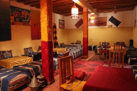 Cette chambre comprend de nombreux lits et chaises. dans l'établissement Hotel Riad Le Petit Prince, à Merzouga