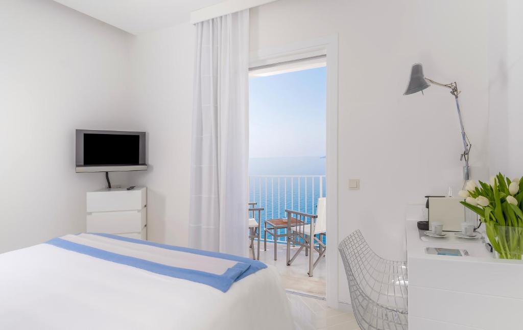 une chambre avec un lit et une vue sur l'océan dans l'établissement Casa Angelina, à Praiano