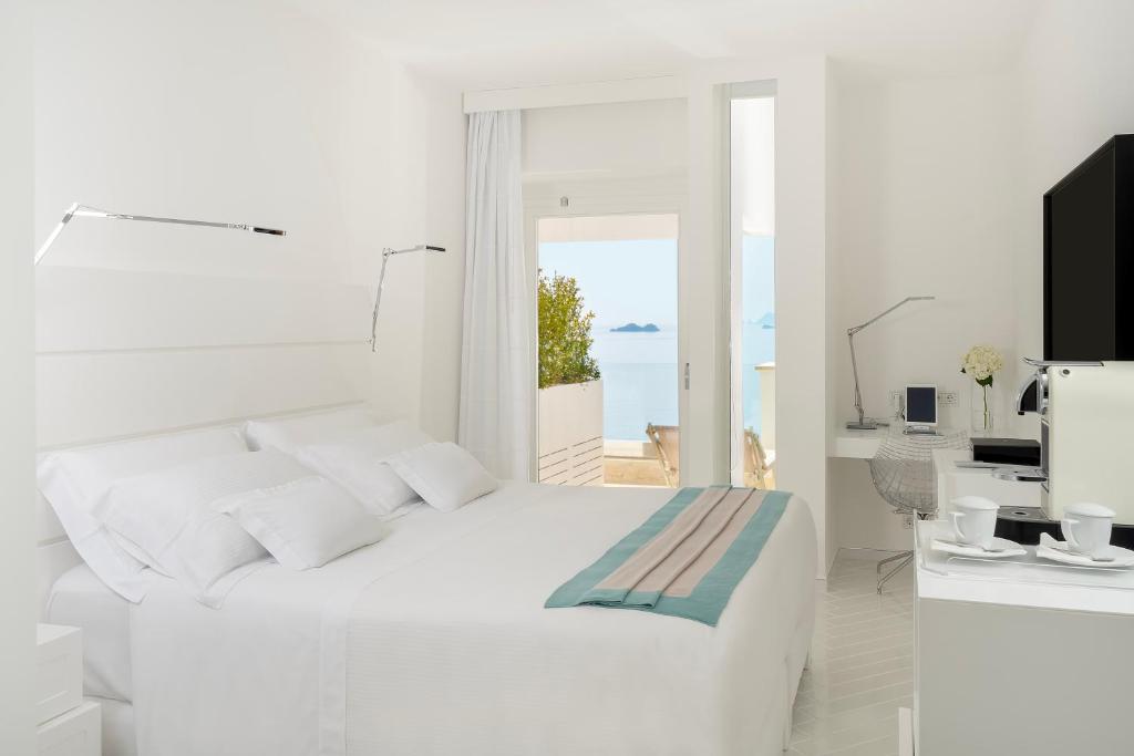 une chambre blanche avec un lit et une vue sur l'océan dans l'établissement Casa Angelina, à Praiano