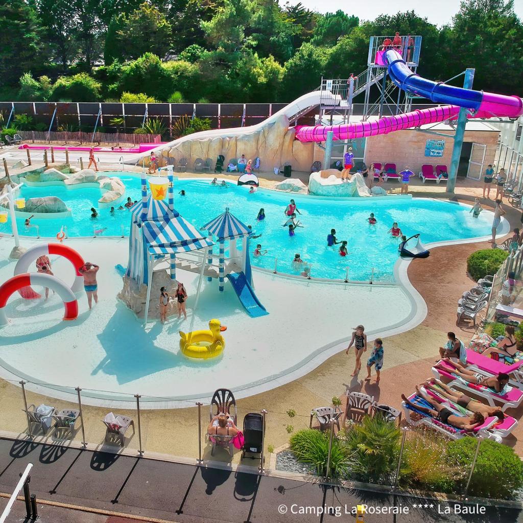 une grande piscine avec des gens dans un parc aquatique dans l'établissement Village Camping La Roseraie, à La Baule 21 autres photos