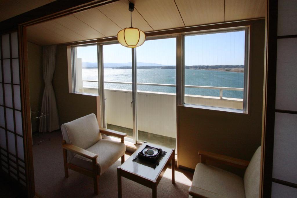un salon avec vue sur l'océan dans l'établissement Kohan No Yado Yoshidaya, à Sado