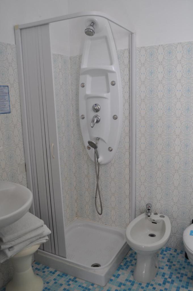 une salle de bain avec une douche, des toilettes et un lavabo dans l'établissement Hotel Rigobello, à Riccione