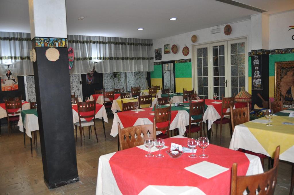 un restaurant avec des tables et des chaises avec une nappe rouge dans l'établissement Hotel Rigobello, à Riccione 19 autres photos