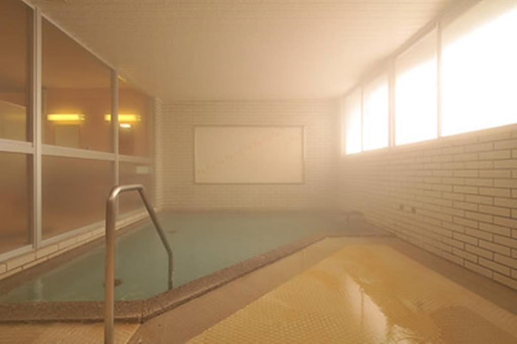 La salle de bains est pourvue d'une baignoire et d'une fenêtre. dans l'établissement Hotel Takimoto, à Yamanouchi