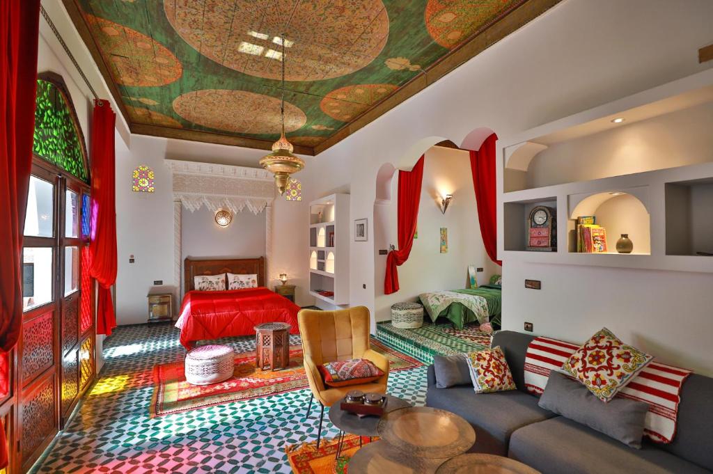 un salon avec un canapé et un lit dans l'établissement Riad Le Moucharabieh, à Fès 37 autres photos