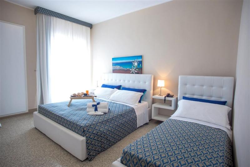 une chambre avec deux lits et une fenêtre dans l'établissement Hotel Lo Scoglio, à Porto Cesareo 25 autres photos