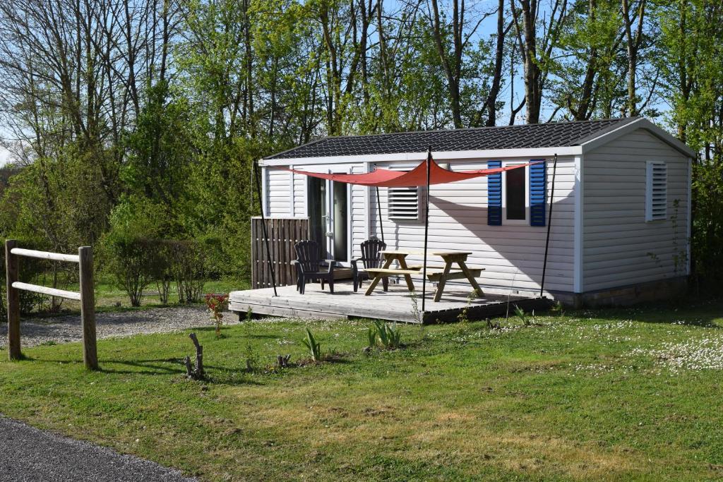 Cette petite maison dispose d'une table de pique-nique et d'une terrasse. dans l'établissement Camping La Croix Badeau, à Soulaines-Dhuys