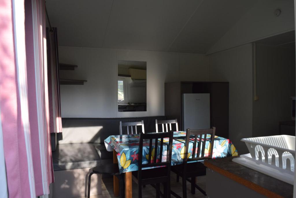 une salle à manger avec deux chaises et une table avec dans l'établissement Camping La Croix Badeau, à Soulaines-Dhuys