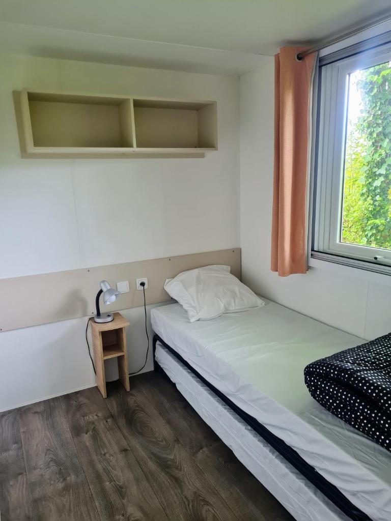 une petite chambre avec un lit et une fenêtre dans l'établissement Hebergement dans un Domaine à Litteau, à Litteau