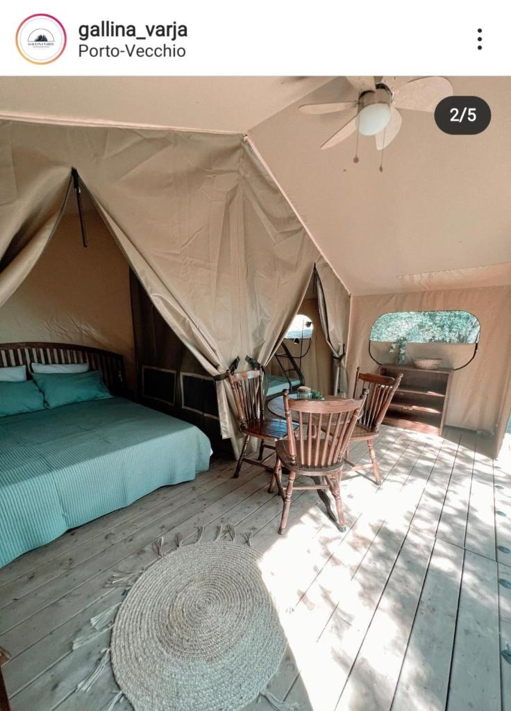 - une chambre avec une tente dotée d'un lit et de chaises dans l'établissement CAMPING GALLINA VARJA, à Sotta