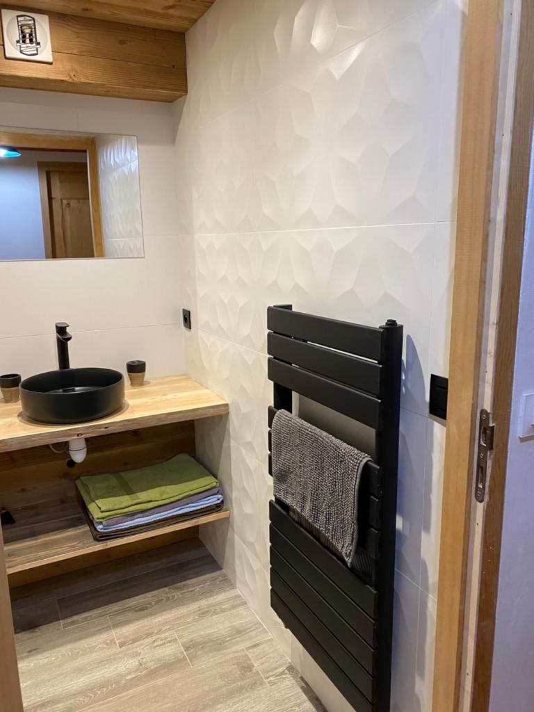 une salle de bain avec un lavabo et un miroir dans l'établissement La Ferme des Georgières "Séjour en tout compris", à Notre-Dame-de-Bellecombe