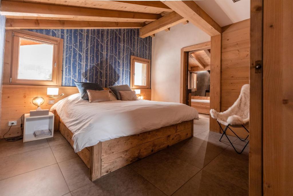une chambre avec un grand lit avec un mur bleu dans l'établissement Large luxury chalet Megeve, à Praz-sur-Arly