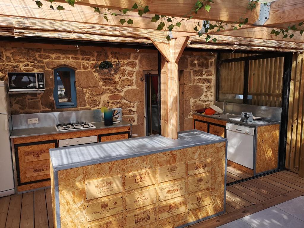 une cuisine avec des armoires en bois et un comptoir dans l'établissement Gite Terradou, à Planzolles
