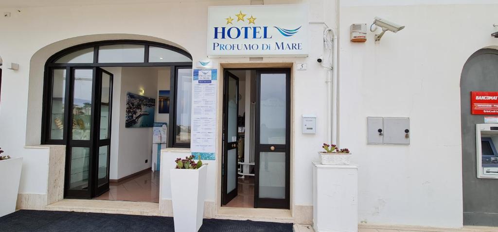 une entrée d'hôtel avec un panneau sur un bâtiment dans l'établissement Hotel Profumo Di Mare, à Otrante