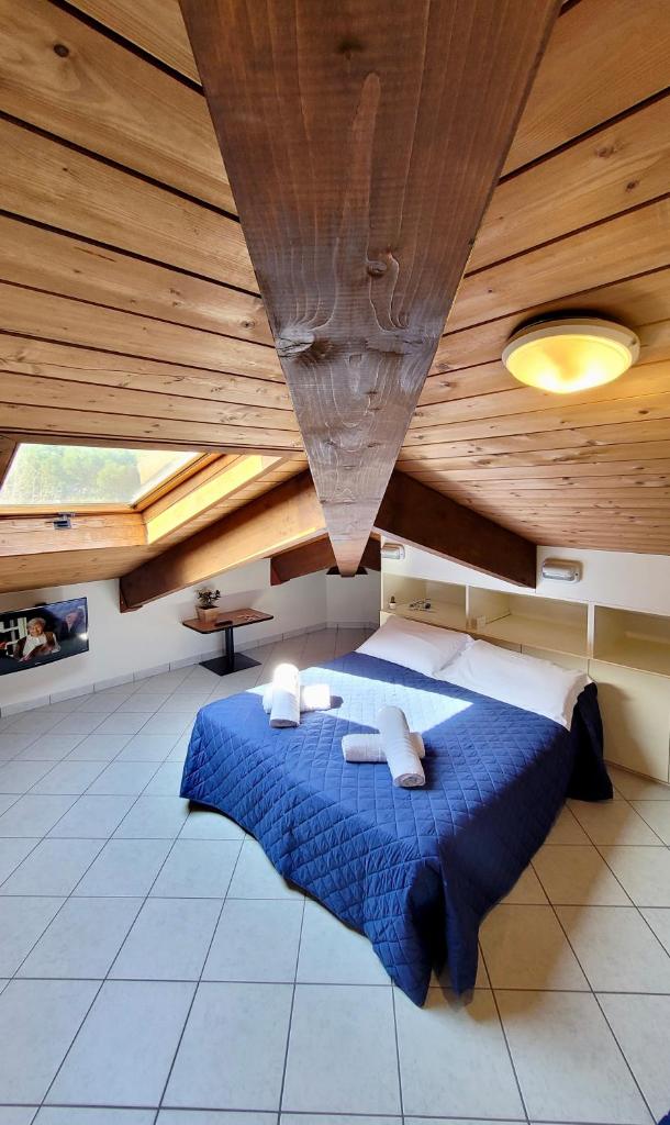 - une chambre avec un lit bleu au plafond en bois dans l'établissement Hotel Adigrat, à Riccione