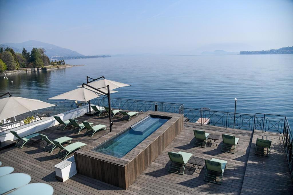 - une piscine avec des chaises et des parasols au bord de l'eau dans l'établissement Hotel Bel Sit, à Meina