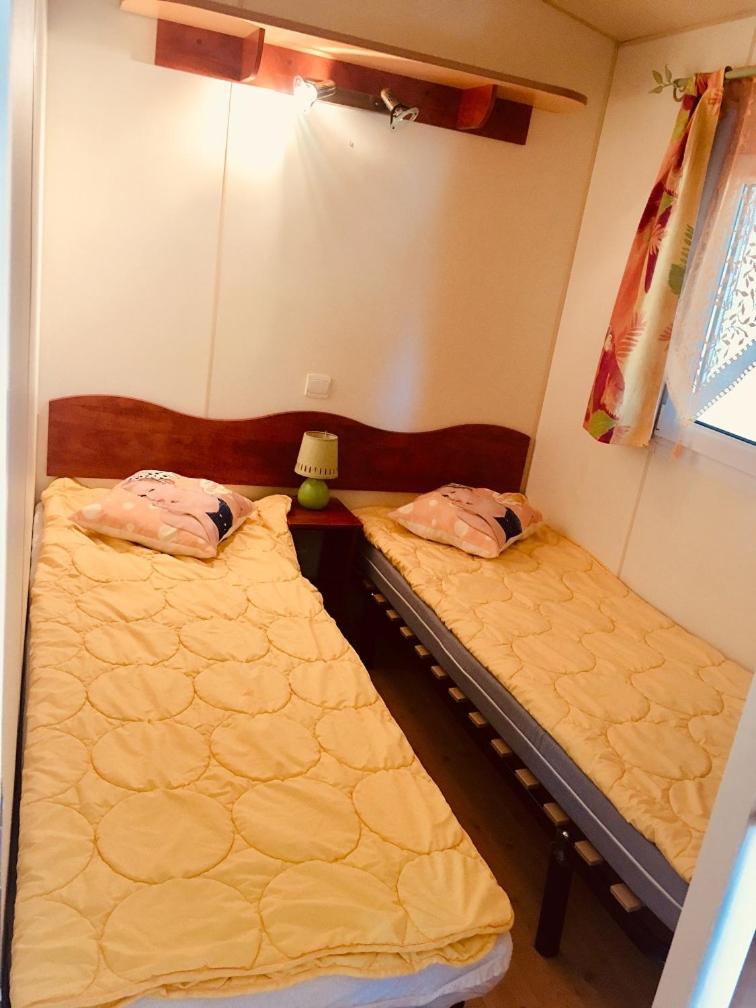 deux lits jumeaux dans une chambre avec dans l'établissement Mobil Home Hyères les palmiers, à Hyères 11 autres photos