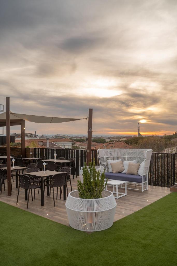 un patio avec un canapé et des tables sur une terrasse dans l'établissement My Place Hotel, à Rimini