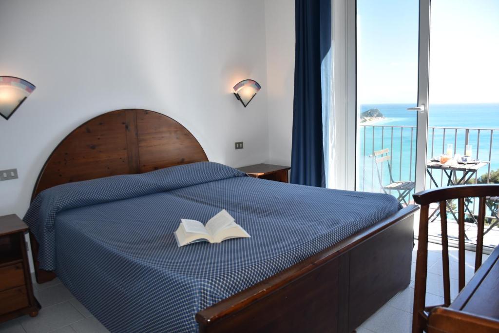 une chambre avec un lit avec un livre dessus dans l'établissement Hotel La Gioiosa, à Finale Ligure