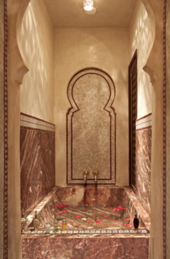 une salle de bain avec une baignoire avec un grand miroir dans l'établissement Mumtaz Mahal, à Essaouira