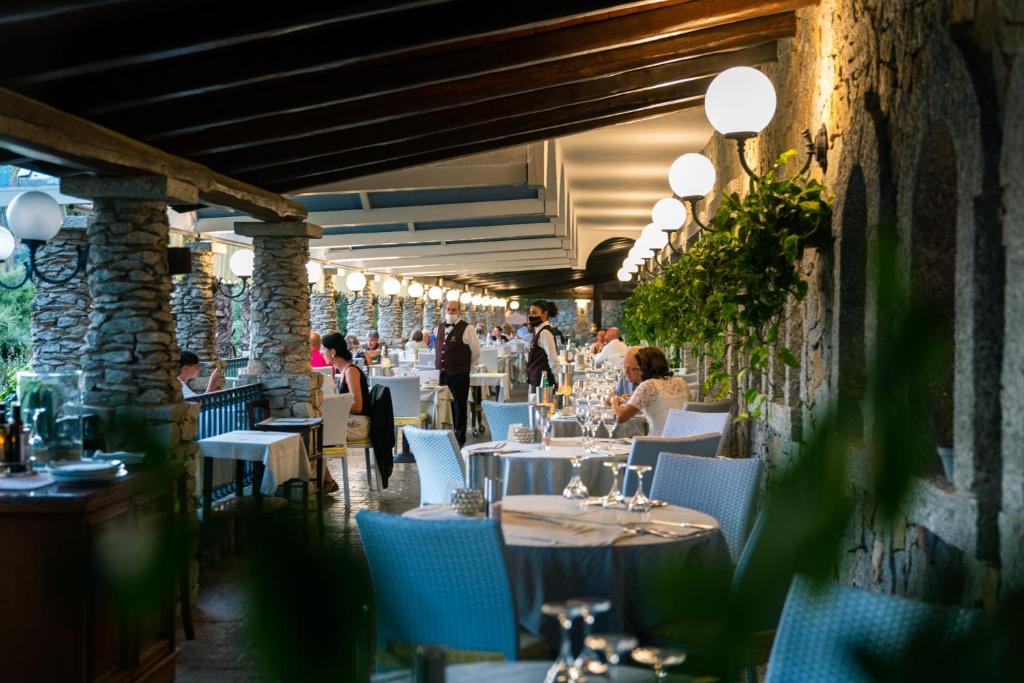 un restaurant avec des tables et des chaises avec des gens assis dessus dans l'établissement Hotel Stella Maris, à Villasimius