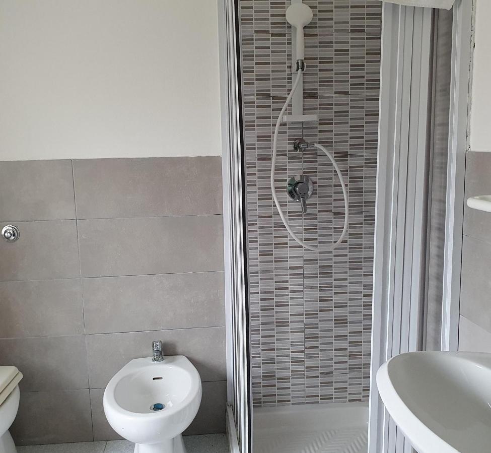 une salle de bain avec une douche, des toilettes et un lavabo dans l'établissement Hotel Pixunte, à Policastro Bussentino