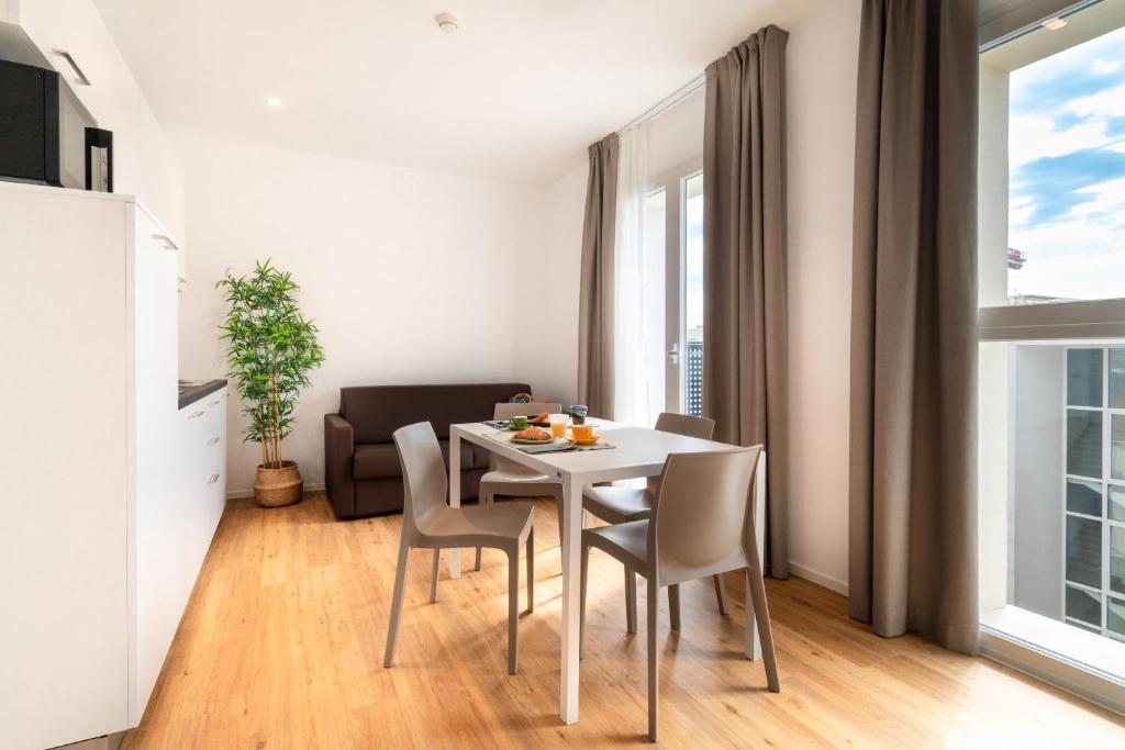 une salle à manger avec une table et des chaises blanches dans l'établissement Superior Beach Aparthotel, à Lido di Jesolo