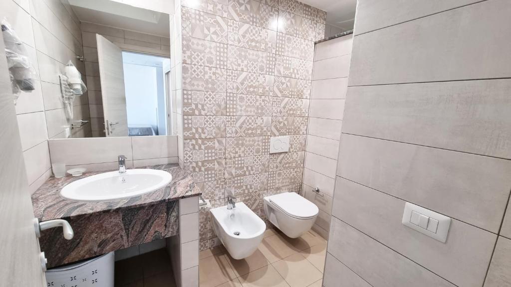 une salle de bain avec un lavabo et des toilettes dans l'établissement Aparthotel Codex, à Rossano 10 autres photos