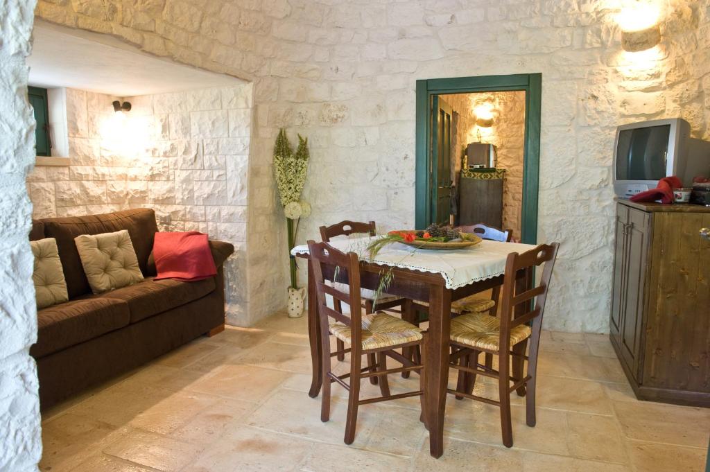 un salon avec une table, des chaises et un canapé dans l'établissement Villa Trullo Panorama, à Locorotondo