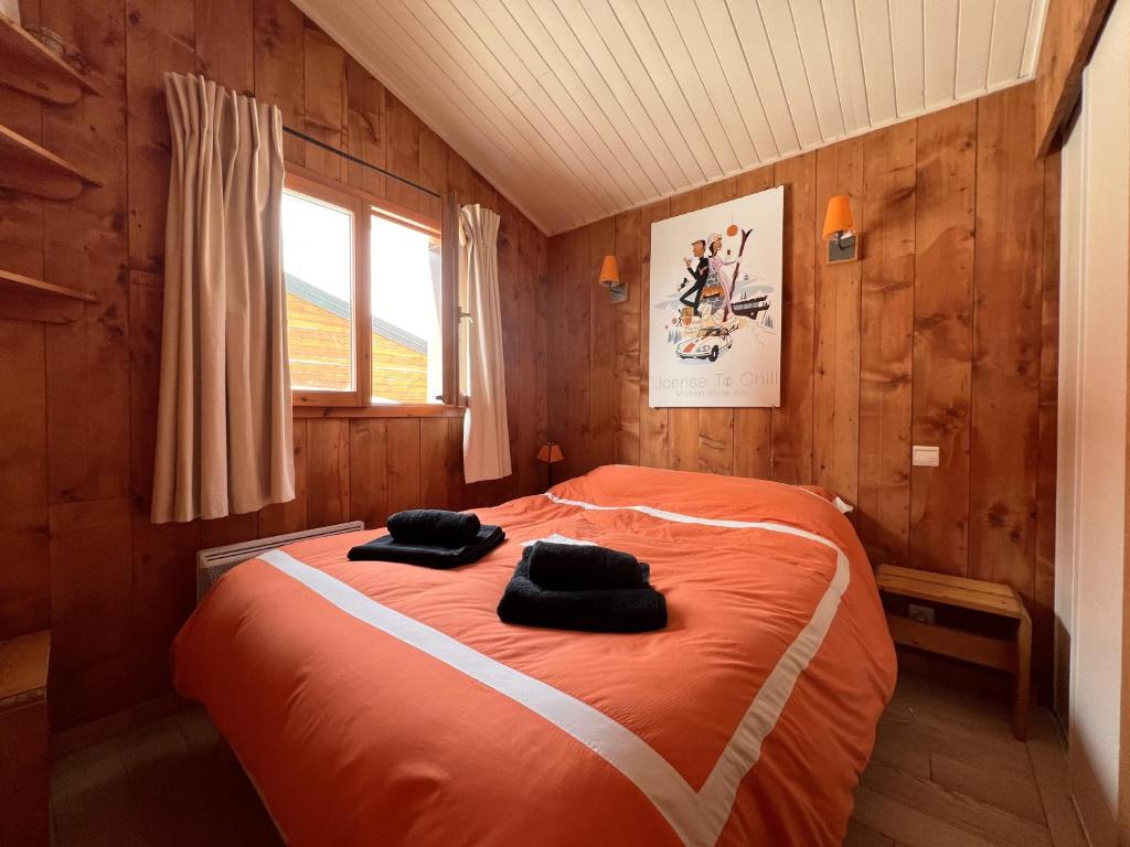- une chambre avec un lit orange et 2 oreillers noirs dans l'établissement Dernier étage avec vue sur les montagnes Emplacement Exceptionnel au cœur de Val Thorens Ski aux pieds Prestations incluses, à Val Thorens