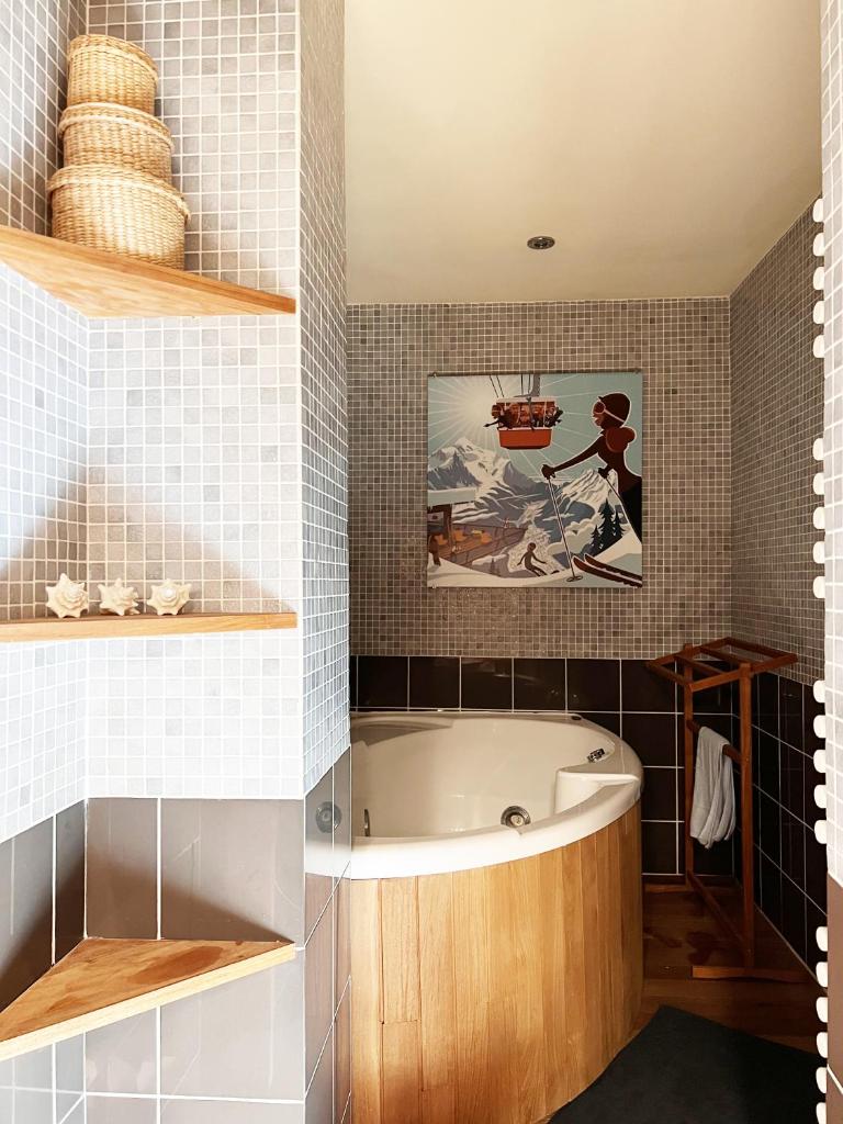 La salle de bains est pourvue d'une baignoire et d'une peinture murale. dans l'établissement Dernier étage avec vue sur les montagnes Emplacement Exceptionnel au cœur de Val Thorens Ski aux pieds Prestations incluses, à Val Thorens 25 autres photos