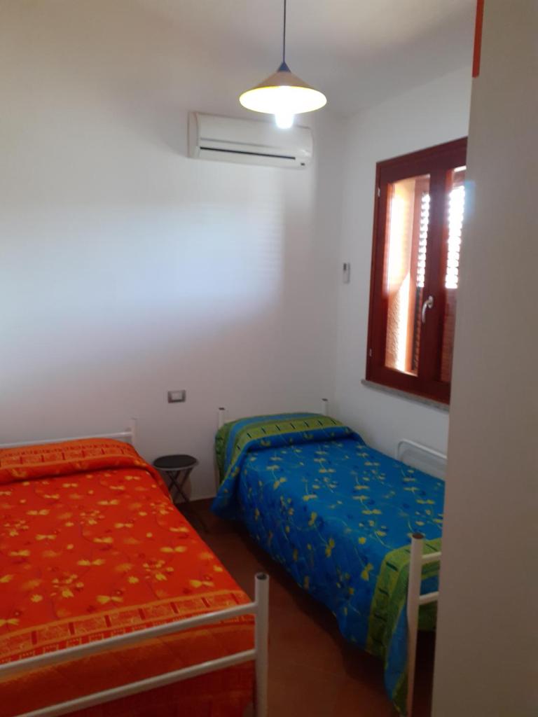 une chambre avec deux lits et une fenêtre dans l'établissement Villa su due livelli super accessoriata, à SantʼAnna Arresi 46 autres photos
