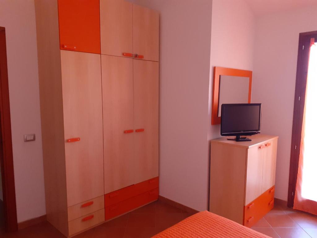 une chambre avec un meuble et une télévision sur une commode dans l'établissement Villa su due livelli super accessoriata, à SantʼAnna Arresi