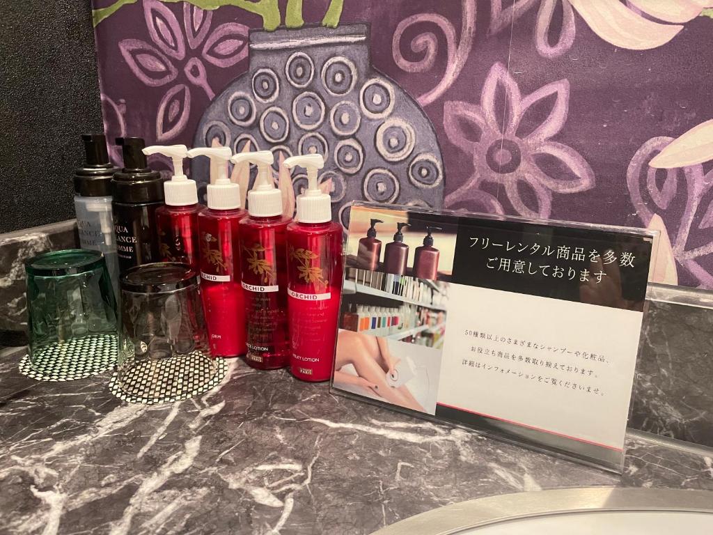 un groupe de bouteilles rouges assises au-dessus d'un comptoir dans l'établissement Hotel LOVE MODERN, à Kitakyūshū