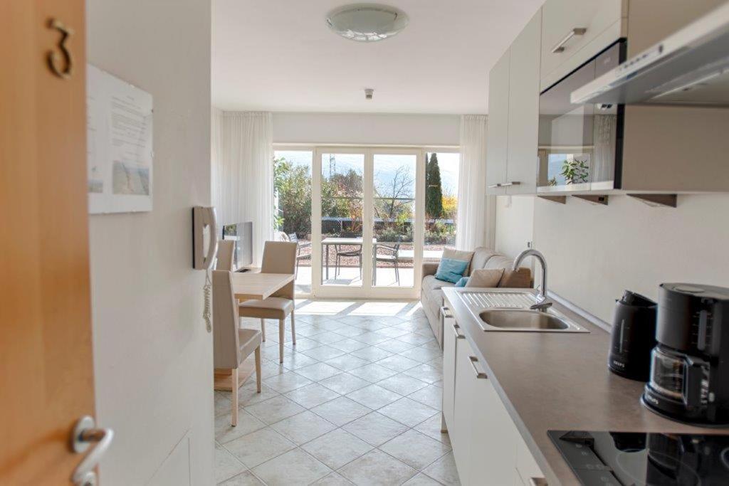 une cuisine avec un évier et un salon dans l'établissement Residence Roland, à Caldaro