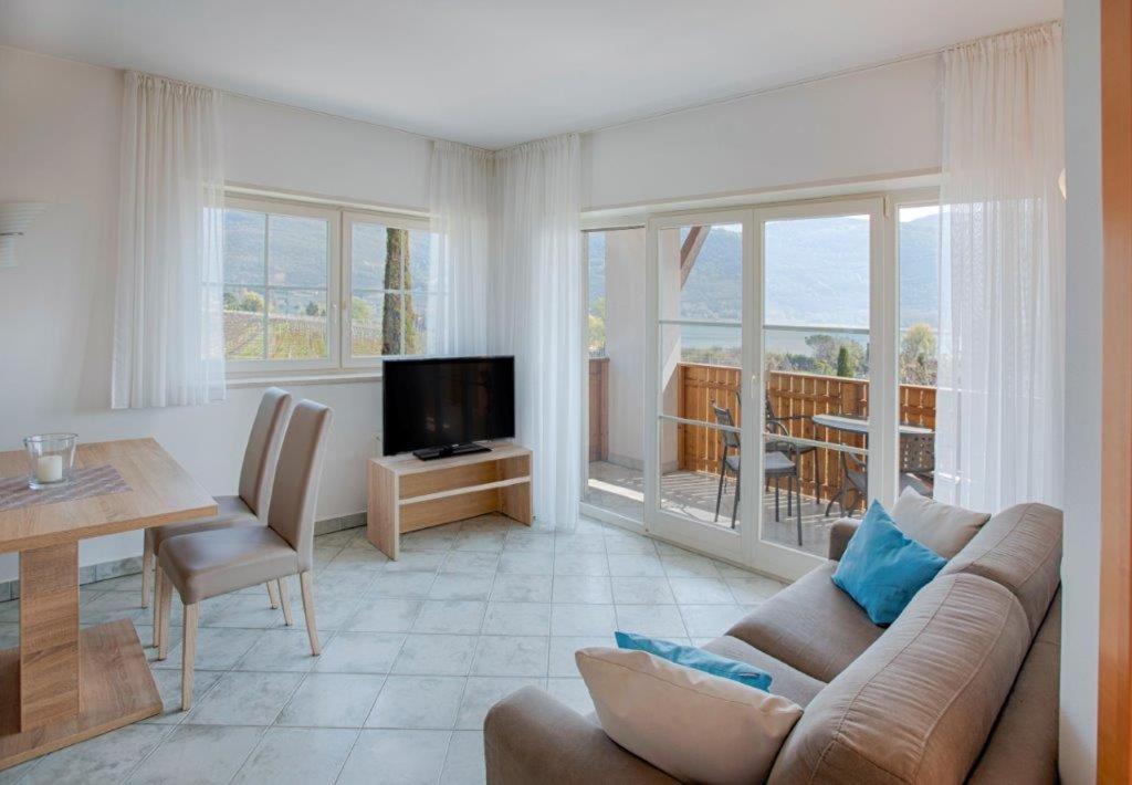 un salon avec un canapé, une table et une télévision dans l'établissement Residence Roland, à Caldaro