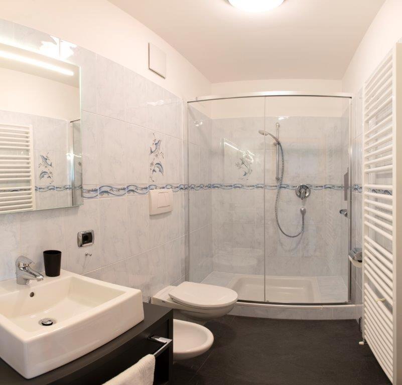 une salle de bain avec une douche, des toilettes et un lavabo dans l'établissement Residence Roland, à Caldaro 32 autres photos
