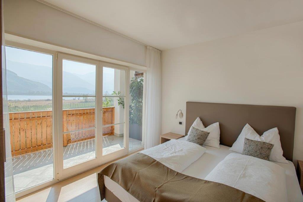 une chambre avec un lit et une grande fenêtre dans l'établissement Residence Roland, à Caldaro