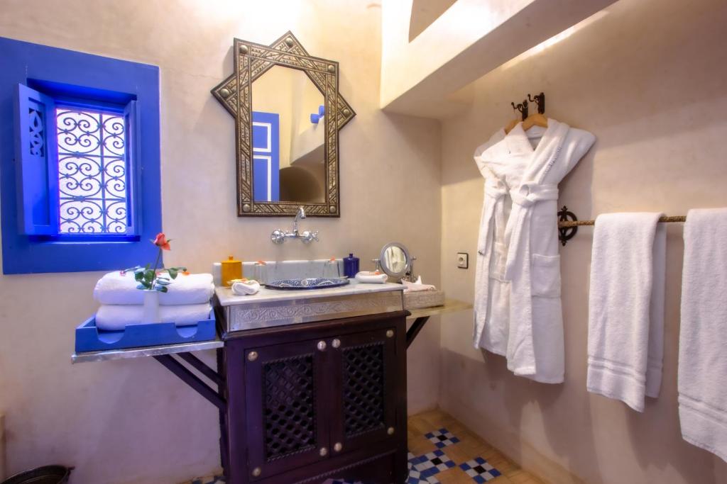 une salle de bain avec un lavabo, un miroir et des serviettes dans l'établissement Riad Kaiss By Anika, à Marrakech 37 autres photos