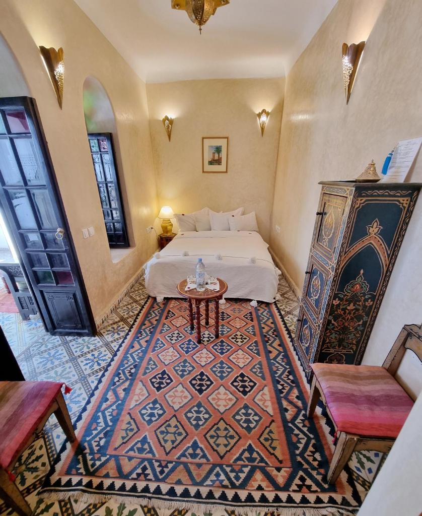 une chambre avec un lit, une table et des chaises dans l'établissement Riad Adriana, à Marrakech