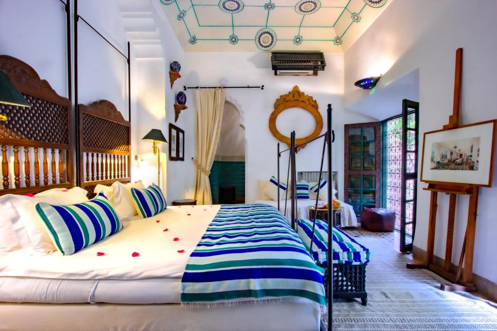 une chambre avec un grand lit avec des oreillers bleus et blancs dans l'établissement Riad Kaiss By Anika, à Marrakech