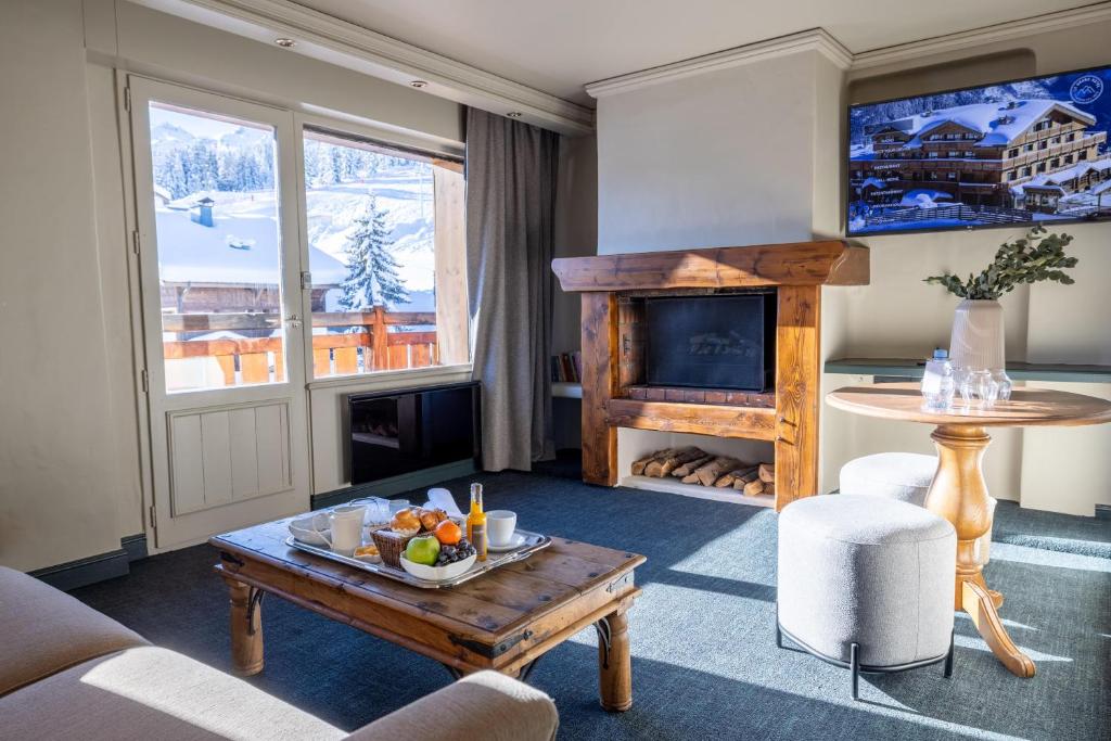 un salon avec une table et une cheminée dans l'établissement Grand Hôtel Courchevel 1850, à Courchevel