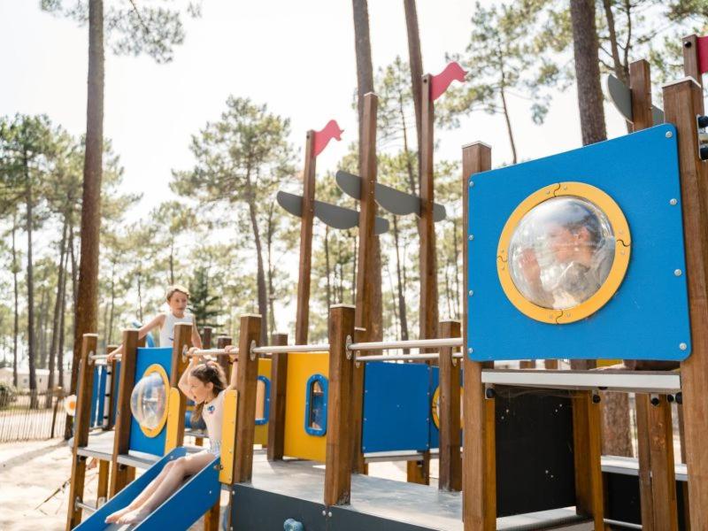 un garçon et une fille jouant sur une aire de jeux dans l'établissement Camping Officiel Siblu Les Dunes de Contis, à Saint-Julien-en-Born