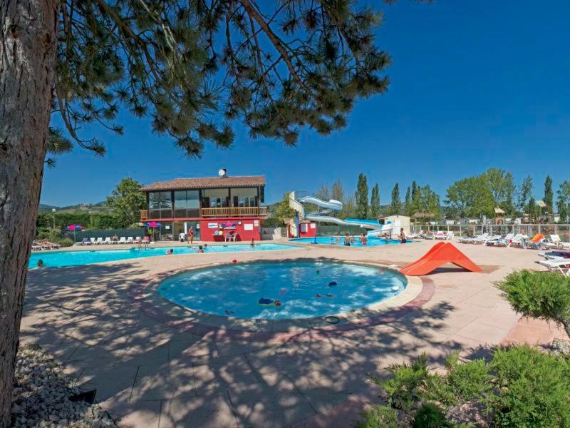 une grande piscine devant un immeuble dans l'établissement Camping Officiel Siblu Les Rives de Condrieu, à Condrieu