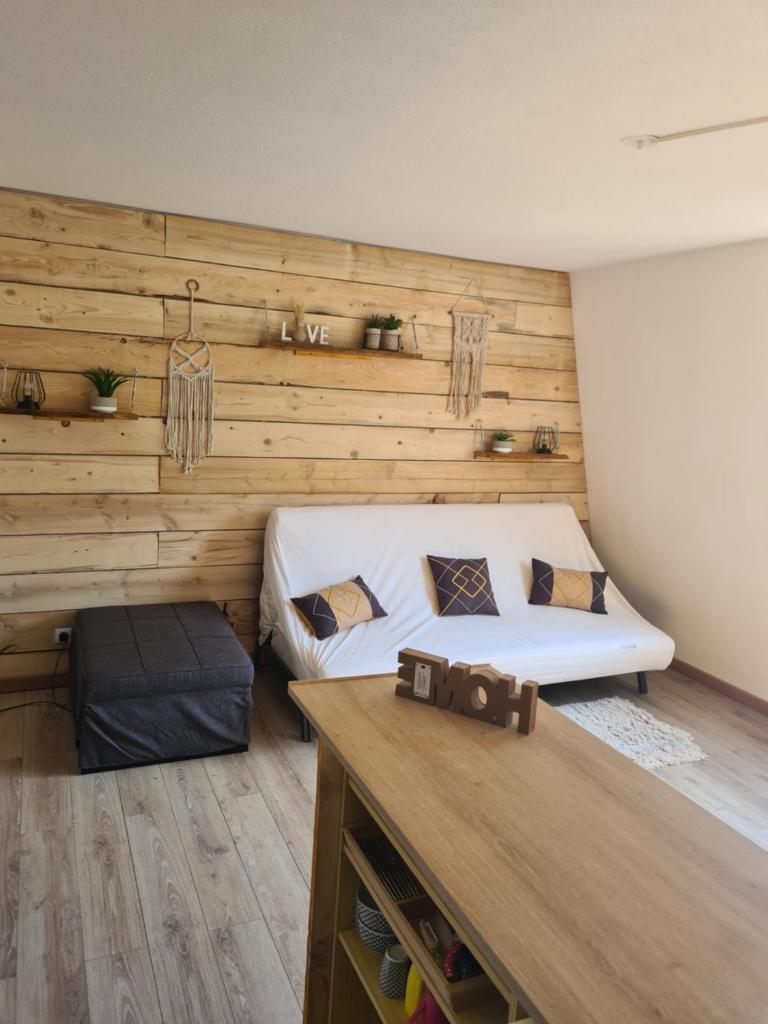 une chambre avec un lit et un mur en bois dans l'établissement grand studio 28 m2 tout confort au pieds des pistes, à La Foux