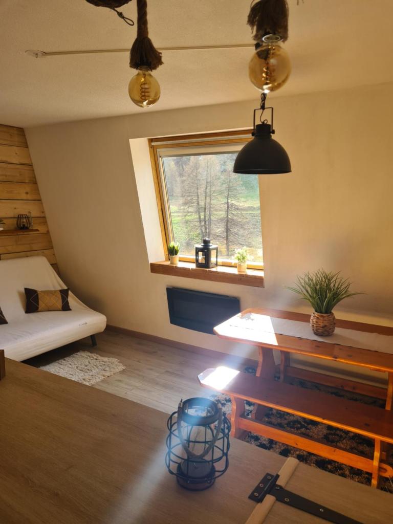 une chambre avec un lit, une table et une fenêtre dans l'établissement grand studio 28 m2 tout confort au pieds des pistes, à La Foux