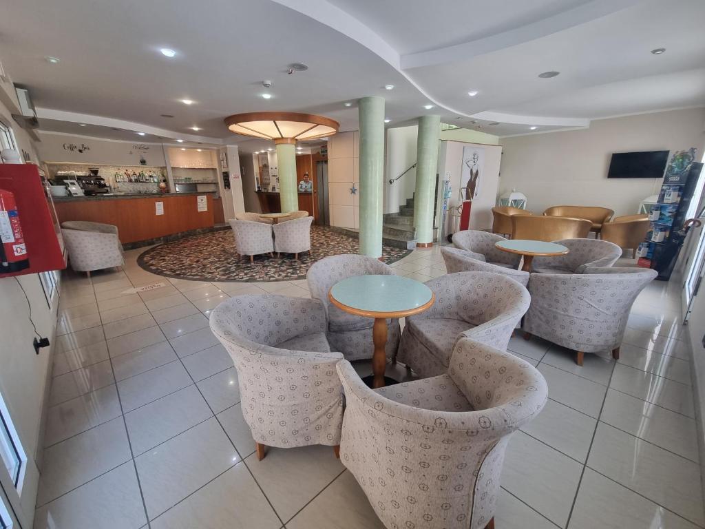 un restaurant avec des tables et des chaises dans un hall dans l'établissement Hotel Marina, à Riccione