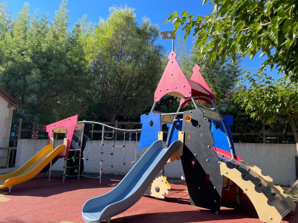 une aire de jeux avec un toboggan dans un parc dans l'établissement Camping de la Treille, à Cavalaire-sur-Mer